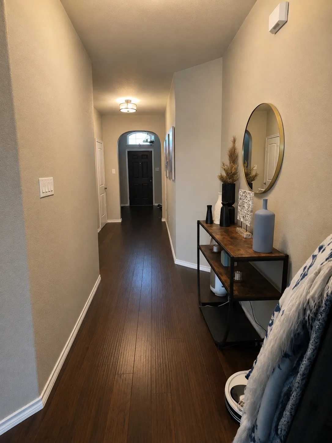 Hallway with wood-finish flooring, recessed lighting, and an arched doorway