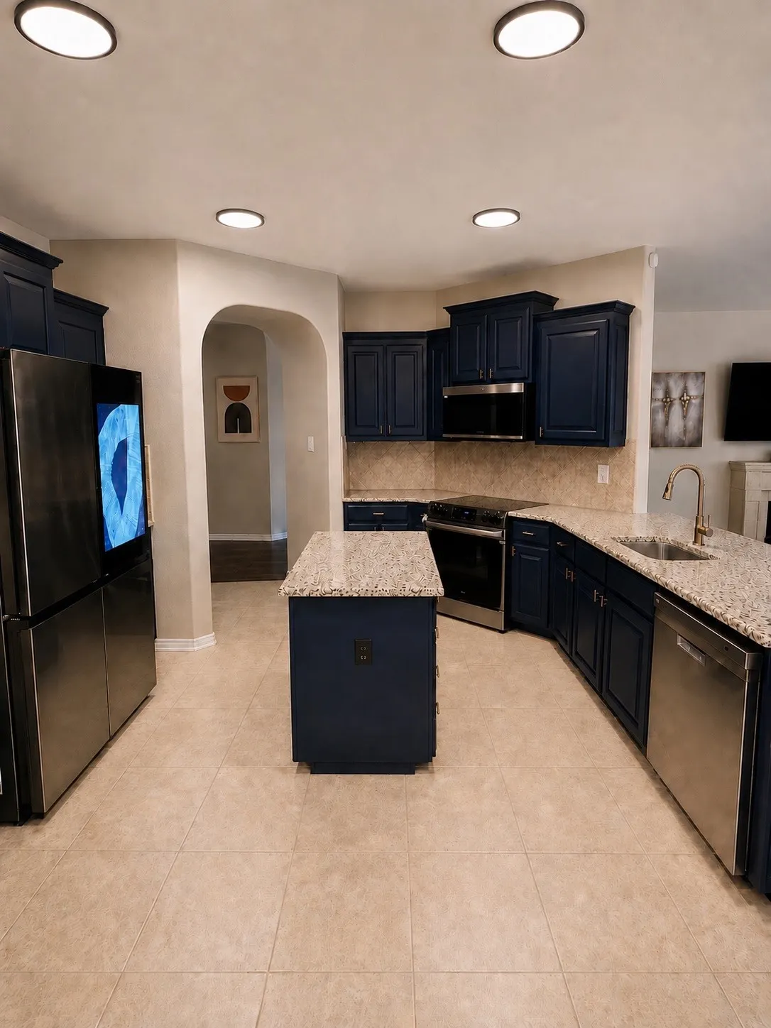 Kitchen featuring a central island, dark blue cabinetry, light-colored tile flooring, stainless steel appliances, and recessed lighting