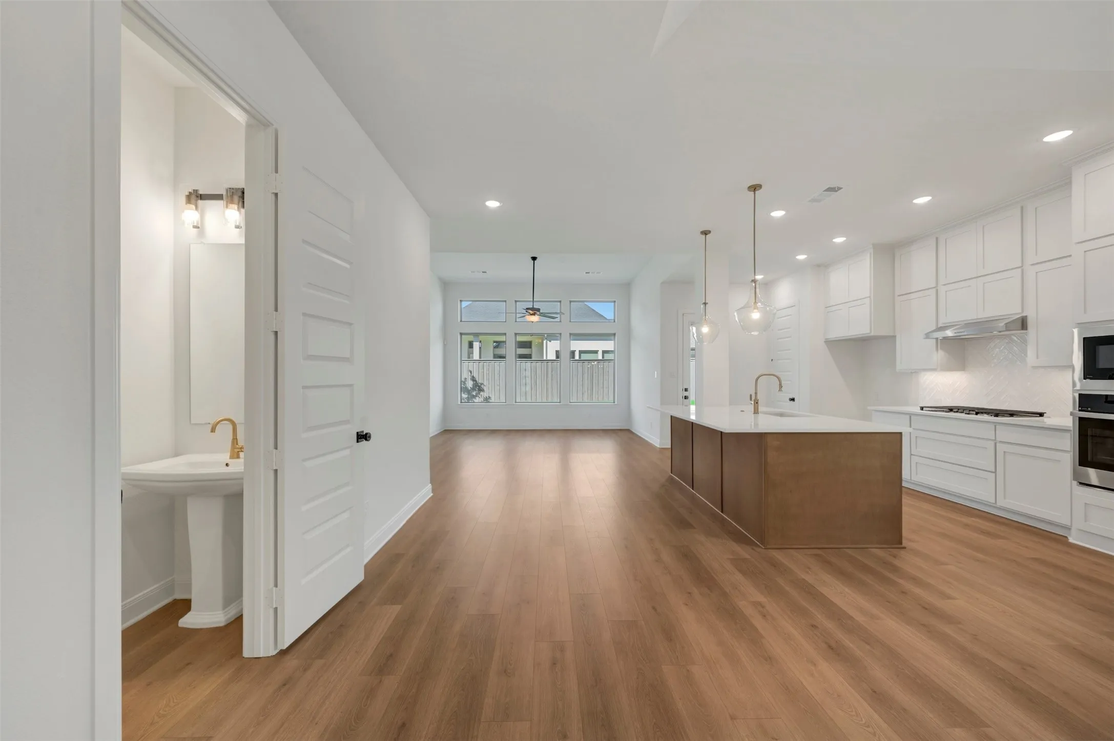 Spacious interior with wood-finish flooring, white walls, and recessed lighting