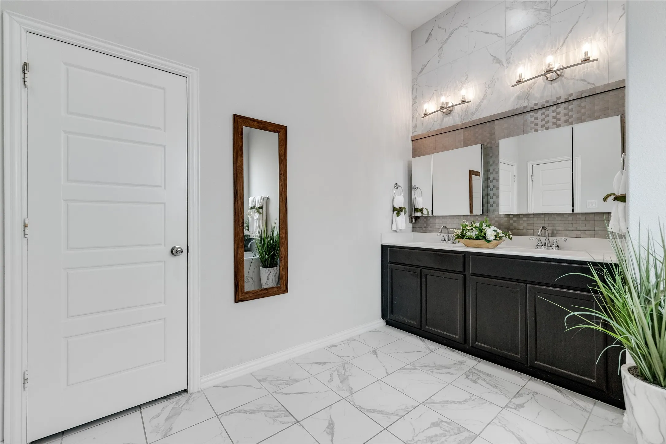 Dual vanity with dark wood-finish cabinetry, polished chrome fixtures, and white countertops