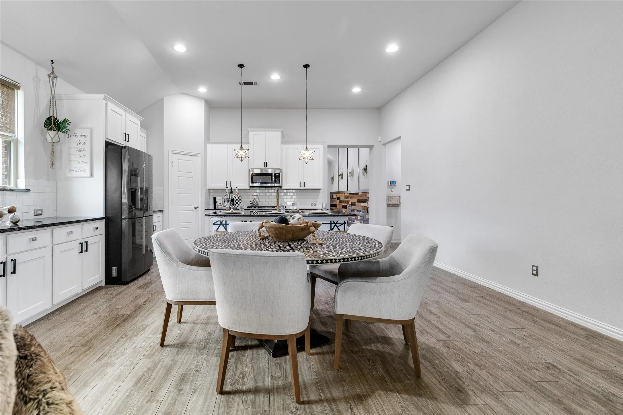 Open-concept living space with wood-finish flooring, recessed lighting, and white walls