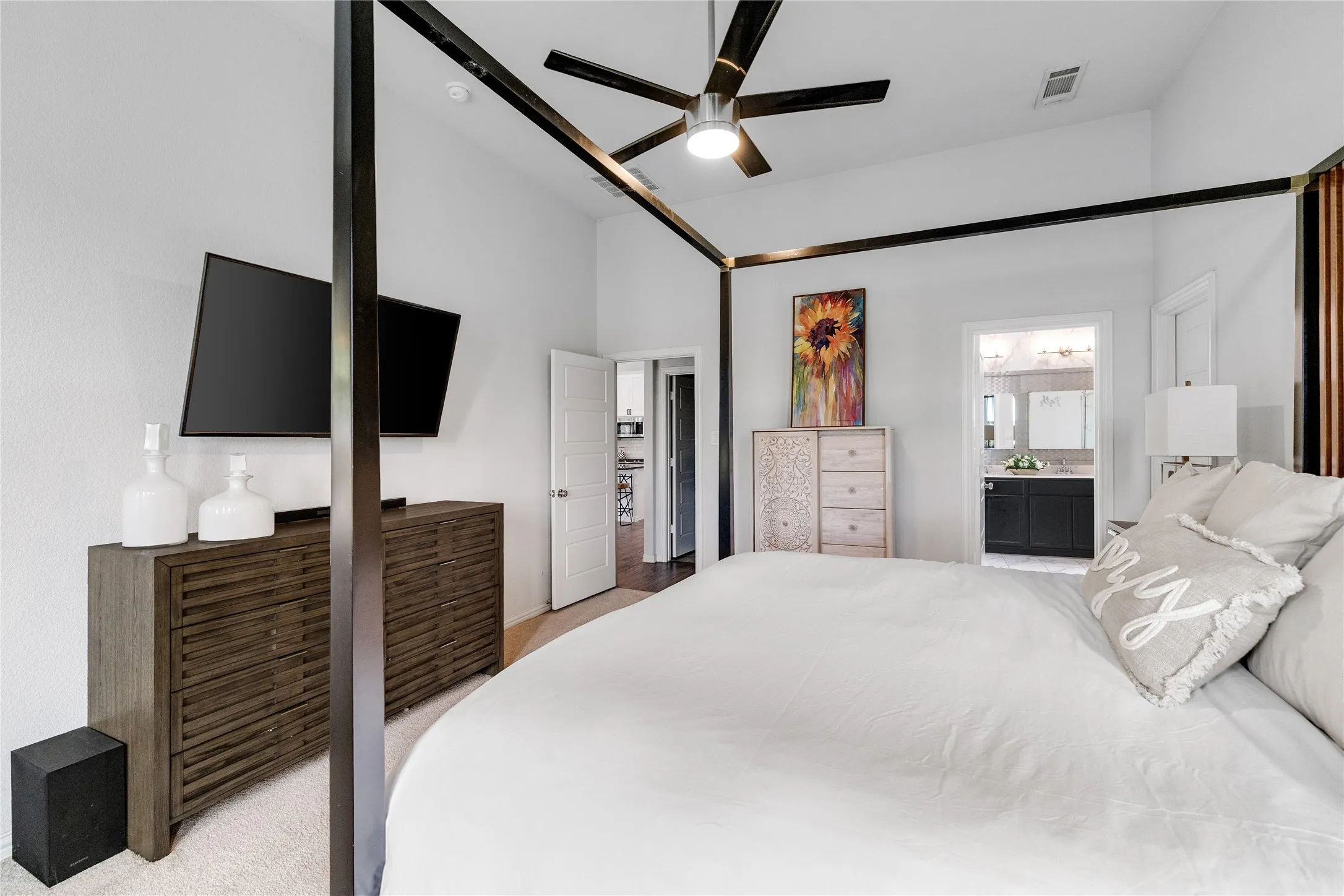 Vaulted ceiling with a ceiling fan, wall-mounted television, and carpet flooring
