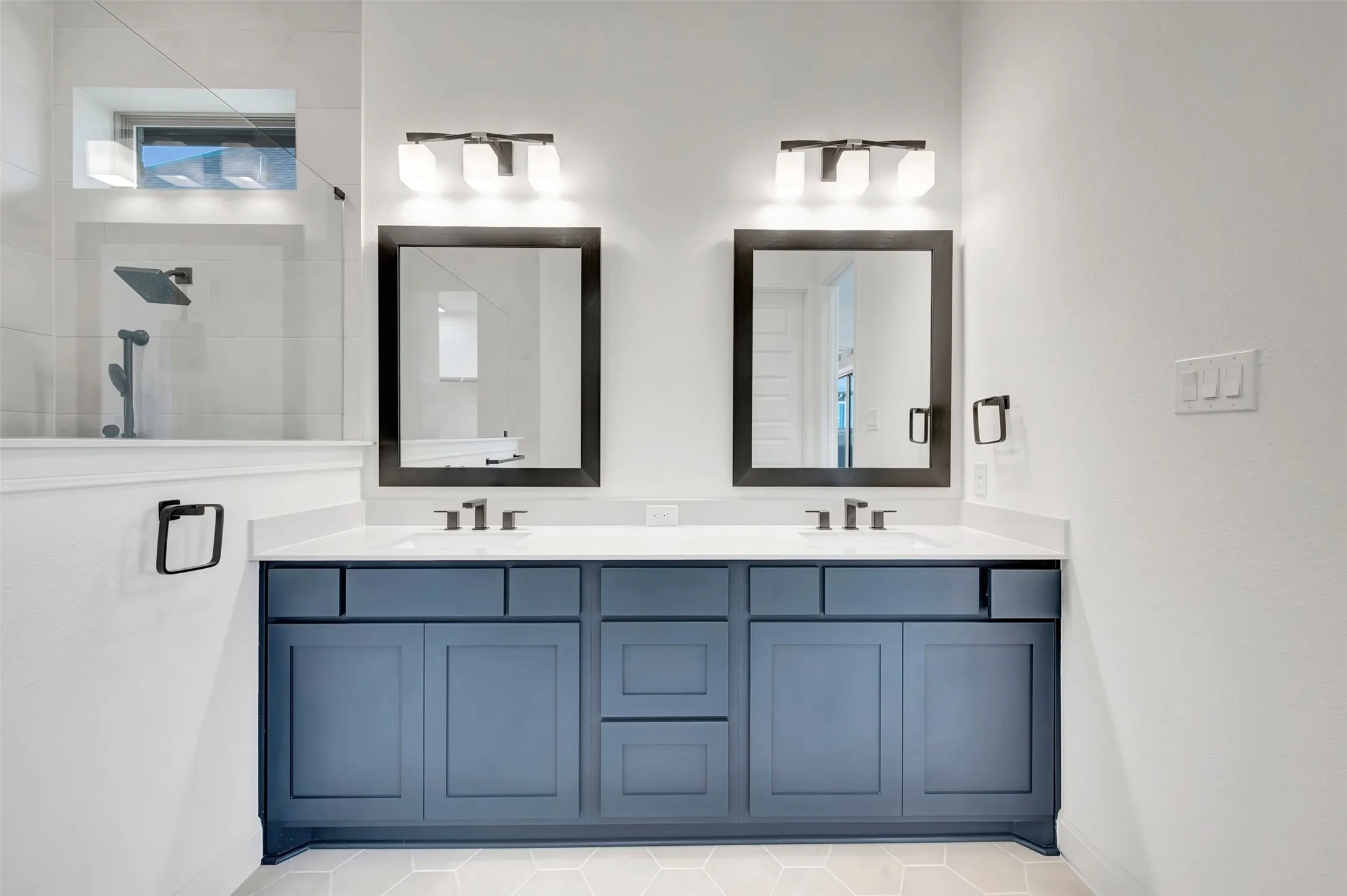Dual vanity with blue shaker-style cabinetry and white countertops