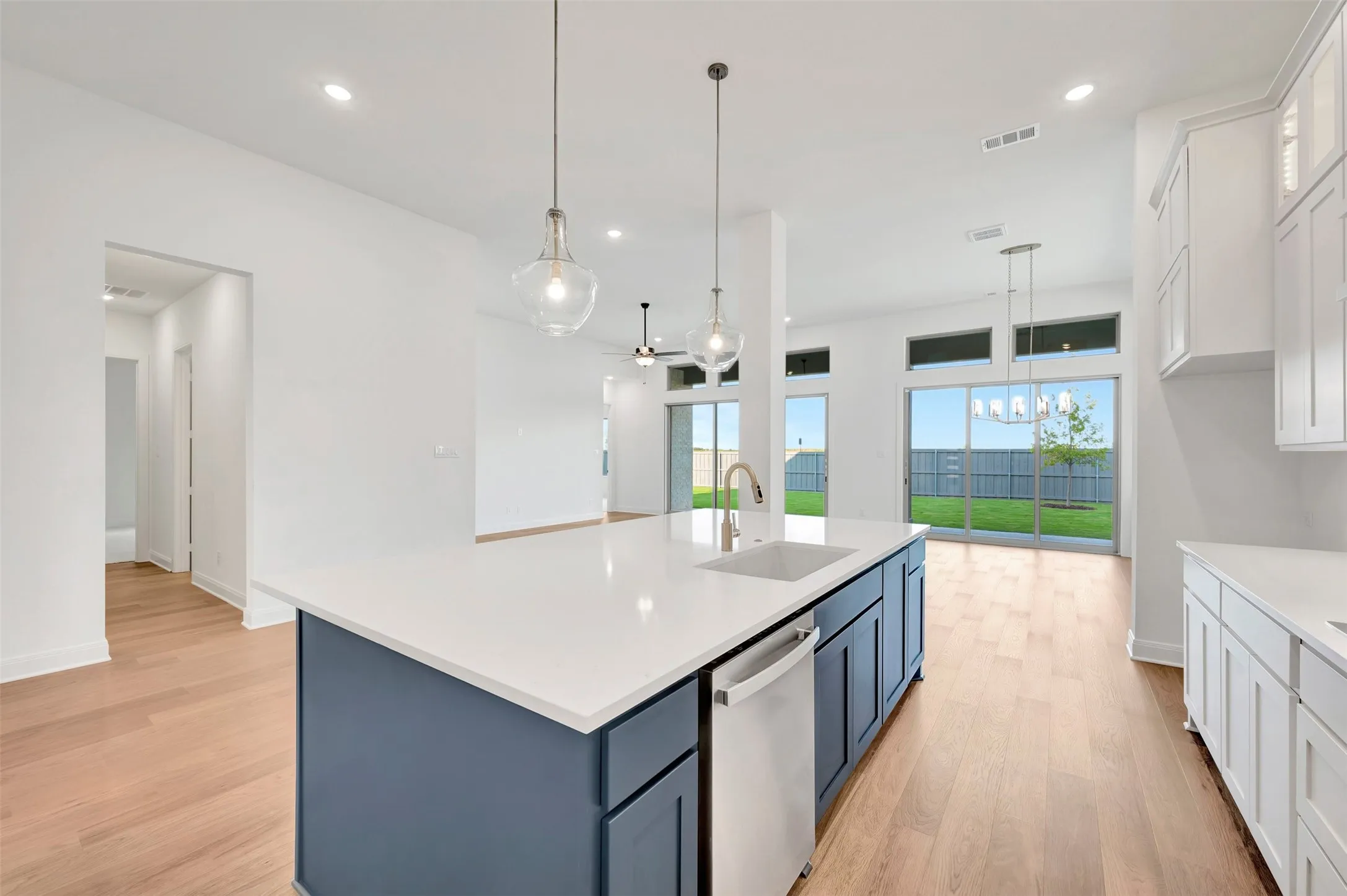 Kitchen island with white countertop, integrated sink, and blue cabinetry