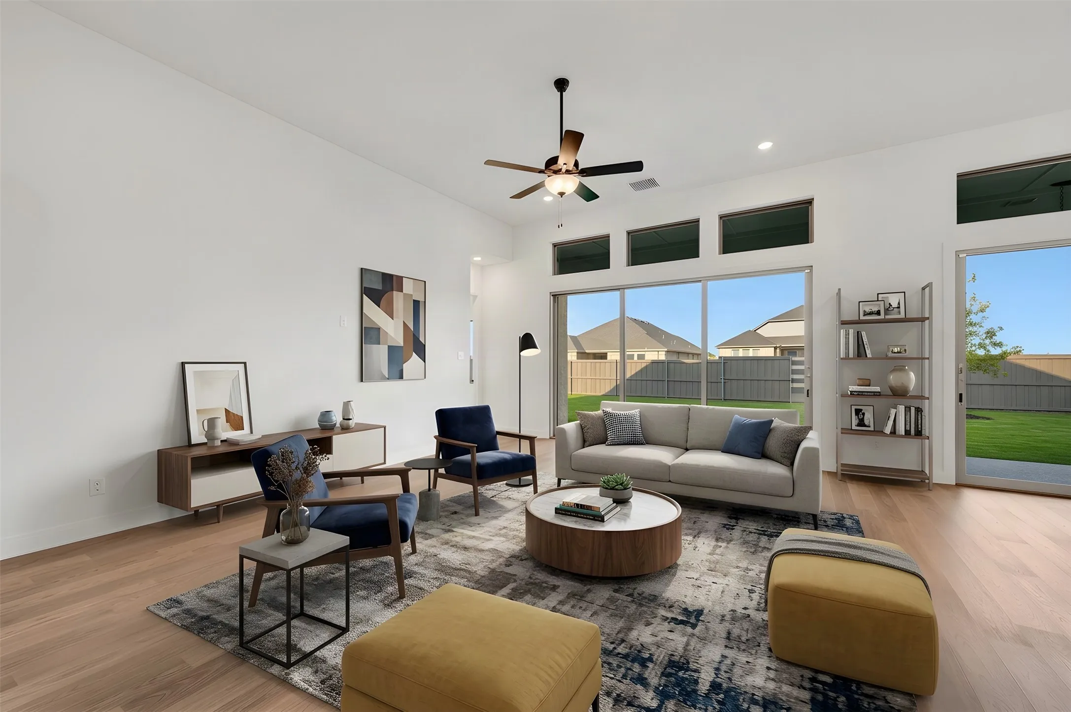 Expansive living area with wood-finish flooring, high ceilings, and recessed lighting