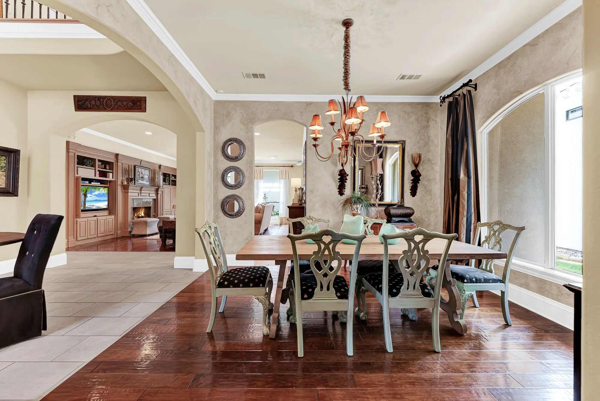 An elegant arched window brings in wonderful light, while open archways connect the dining space smoothly to the surrounding living areas. Imagine hosting intimate dinner parties where conversation flows effortlessly from course to course.