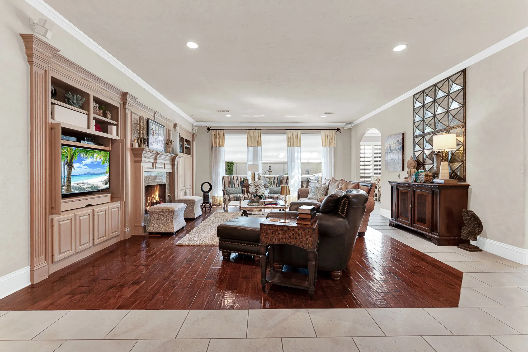 Rich wood floors, custom built-ins with media storage, and a cozy fireplace create a stunning focal point in this spacious family room. You will love unwinding here after a long day or hosting movie nights with family and friends.
