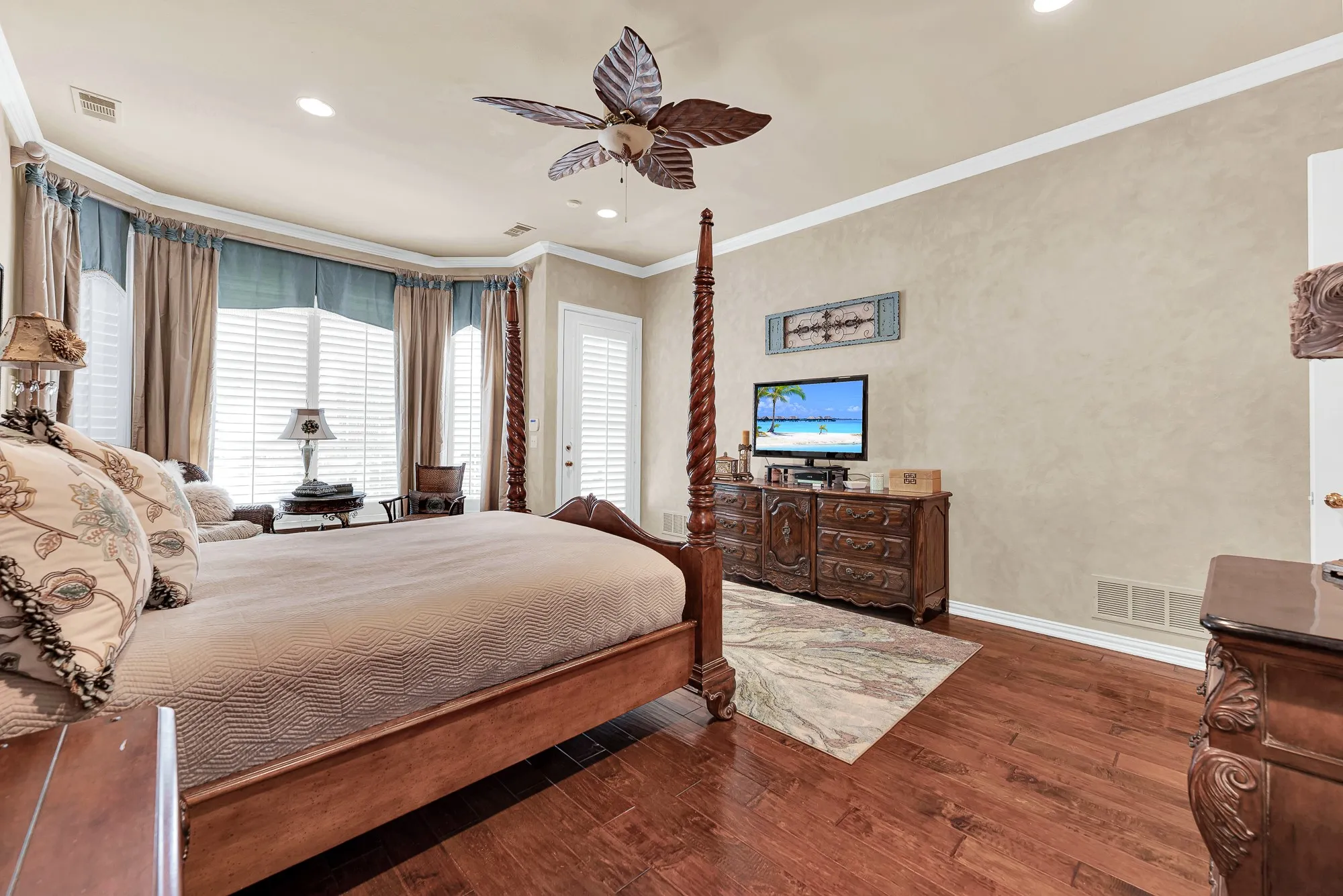 Generous wall space, neutral plaster-style finishes, and large shuttered windows fill this peaceful retreat with gentle natural light. It is the perfect cozy environment to curl up with a good book or relax with a favorite movie before bed.