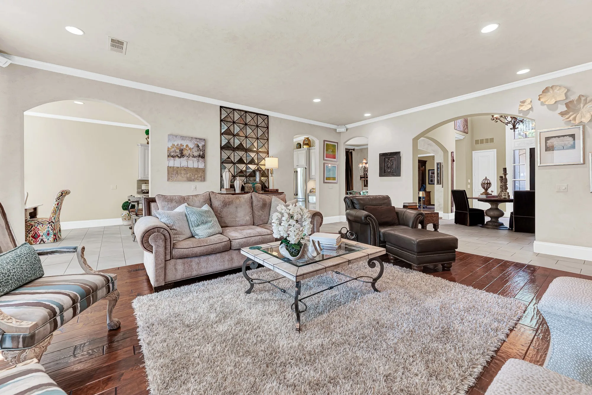 Generous open sightlines sweep across tile and hardwood flooring into the foyer and surrounding living areas. This airy design makes entertaining completely effortless, allowing guests to mingle freely throughout the home.
