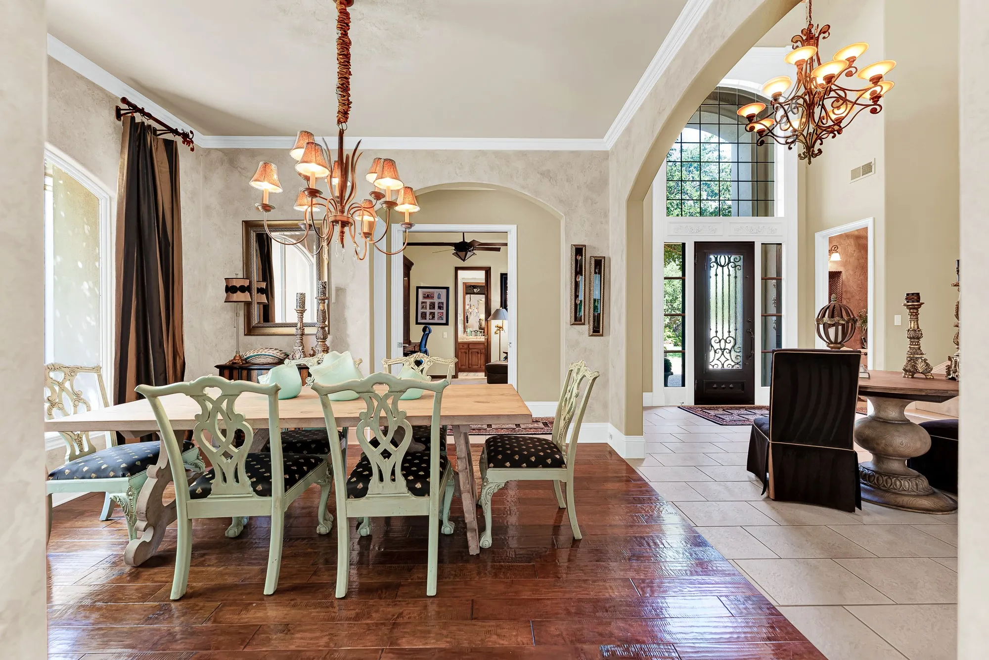 Rich hardwood floors, a multi-light chandelier, and sweeping open arches define this formal dining space looking toward the entryway. Imagine hosting memorable holiday gatherings and dinner parties where guests feel welcome the moment they step inside