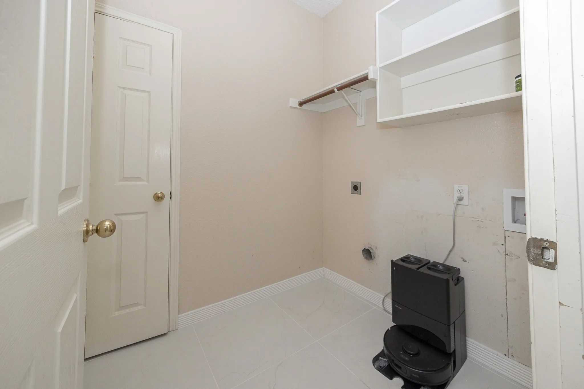 White tile flooring, built-in shelving, and a wall-mounted clothing rod