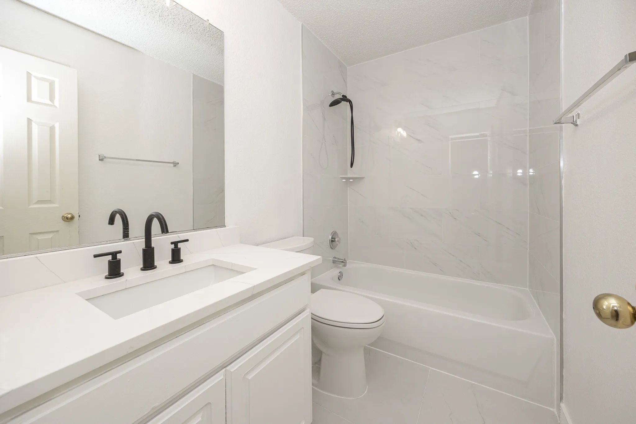 White vanity with an integrated rectangular sink, matte black faucet, and a large wall-mounted mirror