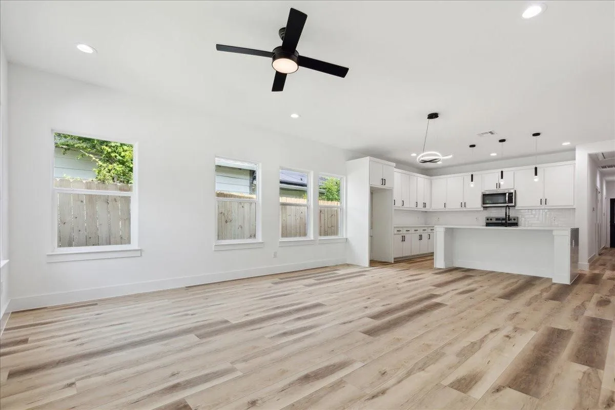 Open-concept living area featuring wood-finish flooring, recessed lighting, and a contemporary ceiling fan