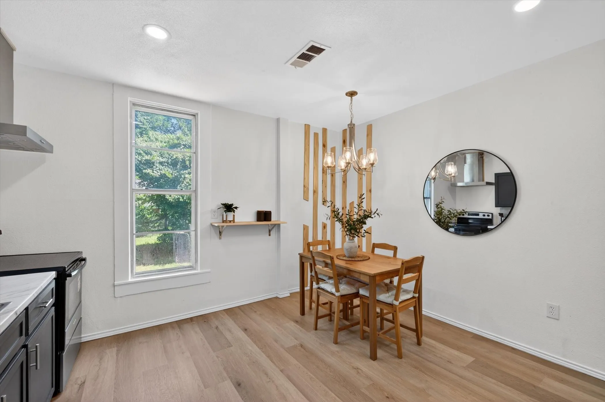 Dining area featuring wood-finish flooring, a contemporary chandelier, and recessed lighting