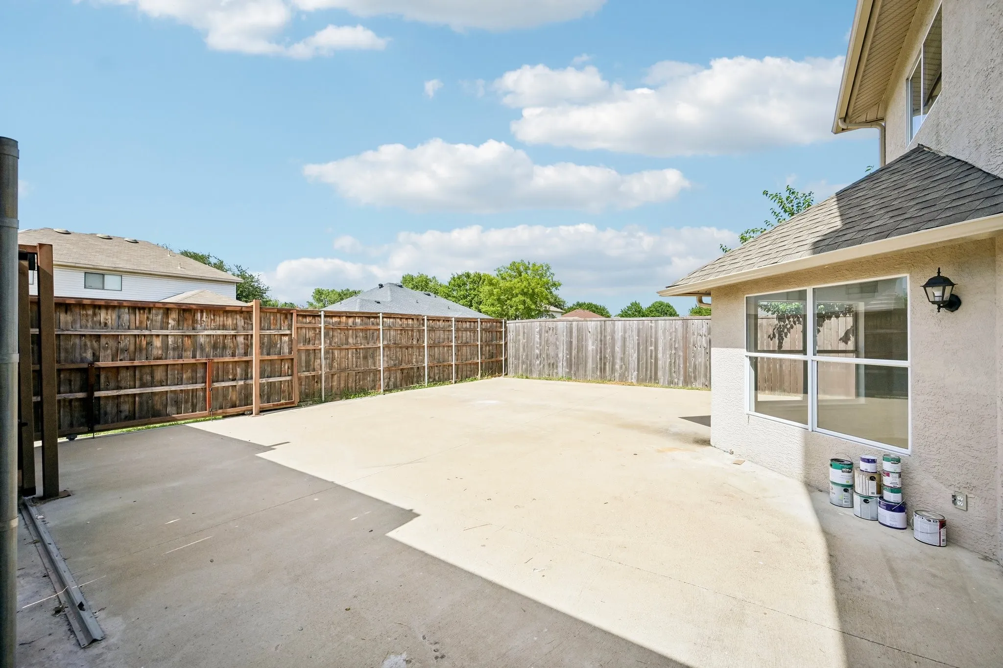Expansive concrete patio with a full privacy fence