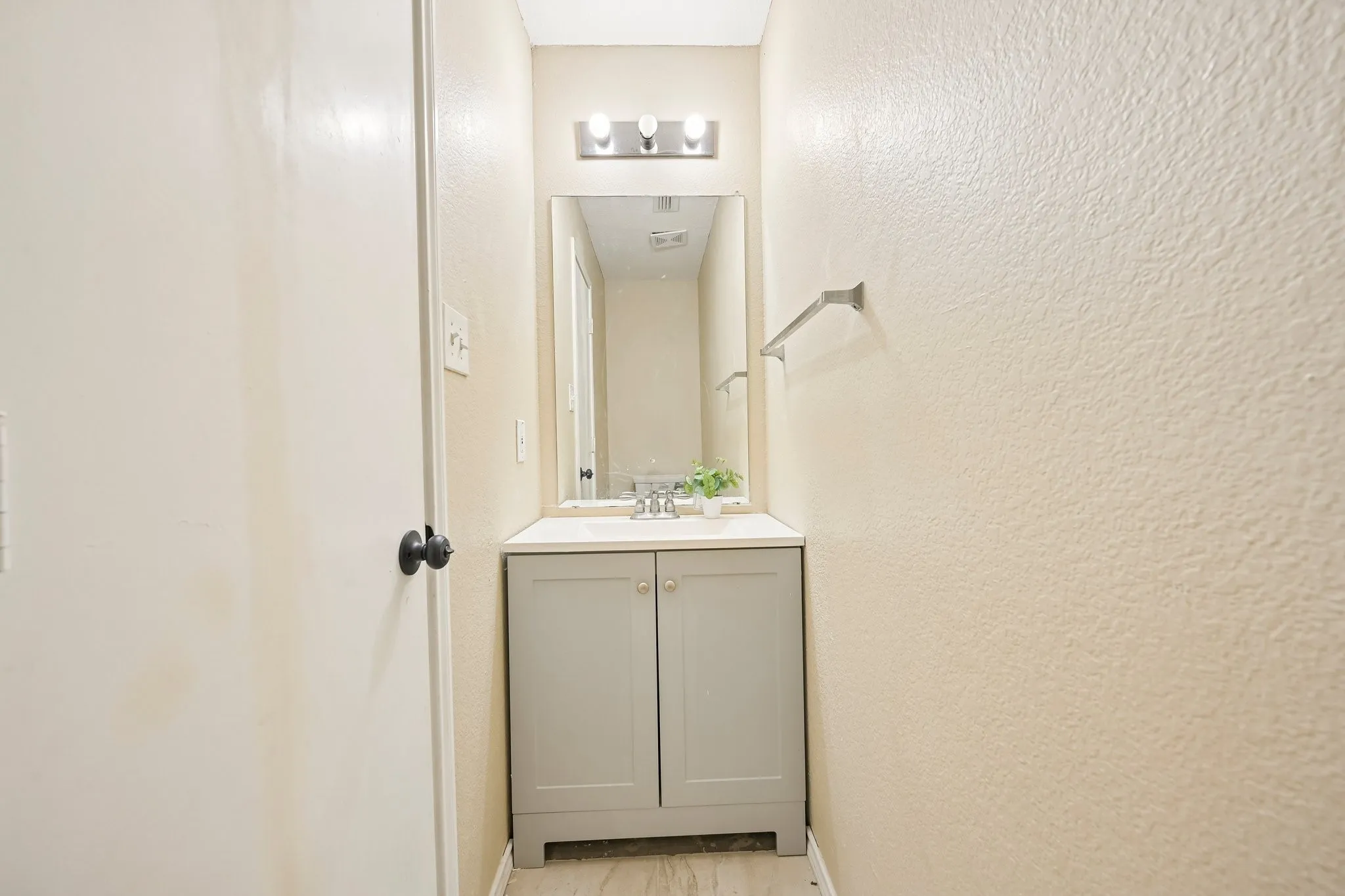 Integrated vanity with light gray cabinetry, white countertop, and rectangular mirror