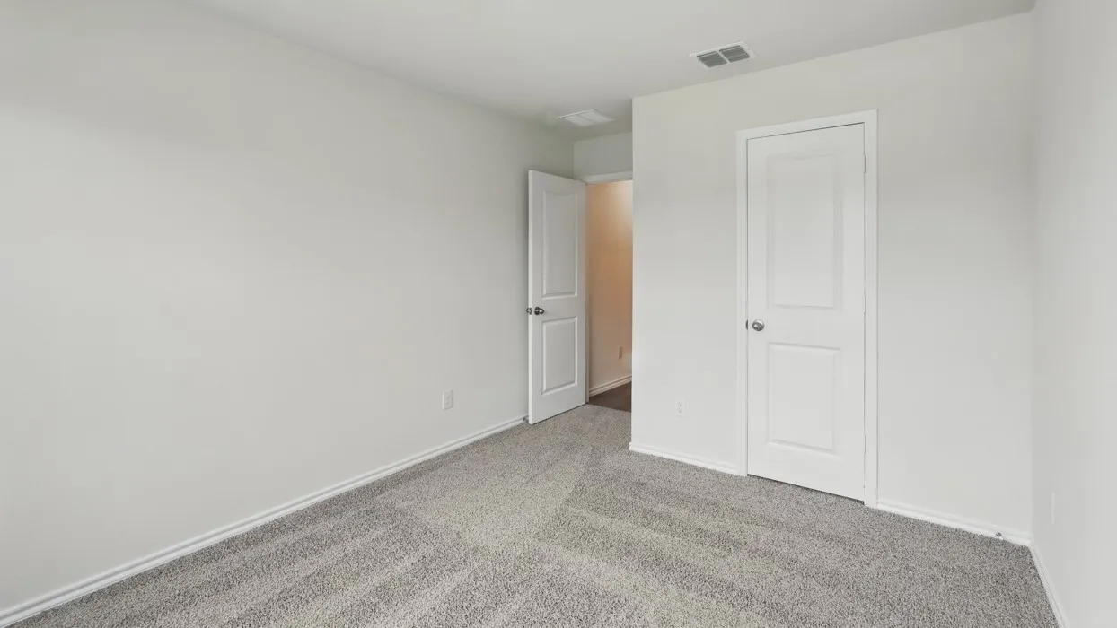 Neutral wall color, light gray carpet flooring, white paneled doors, and recessed ceiling vent