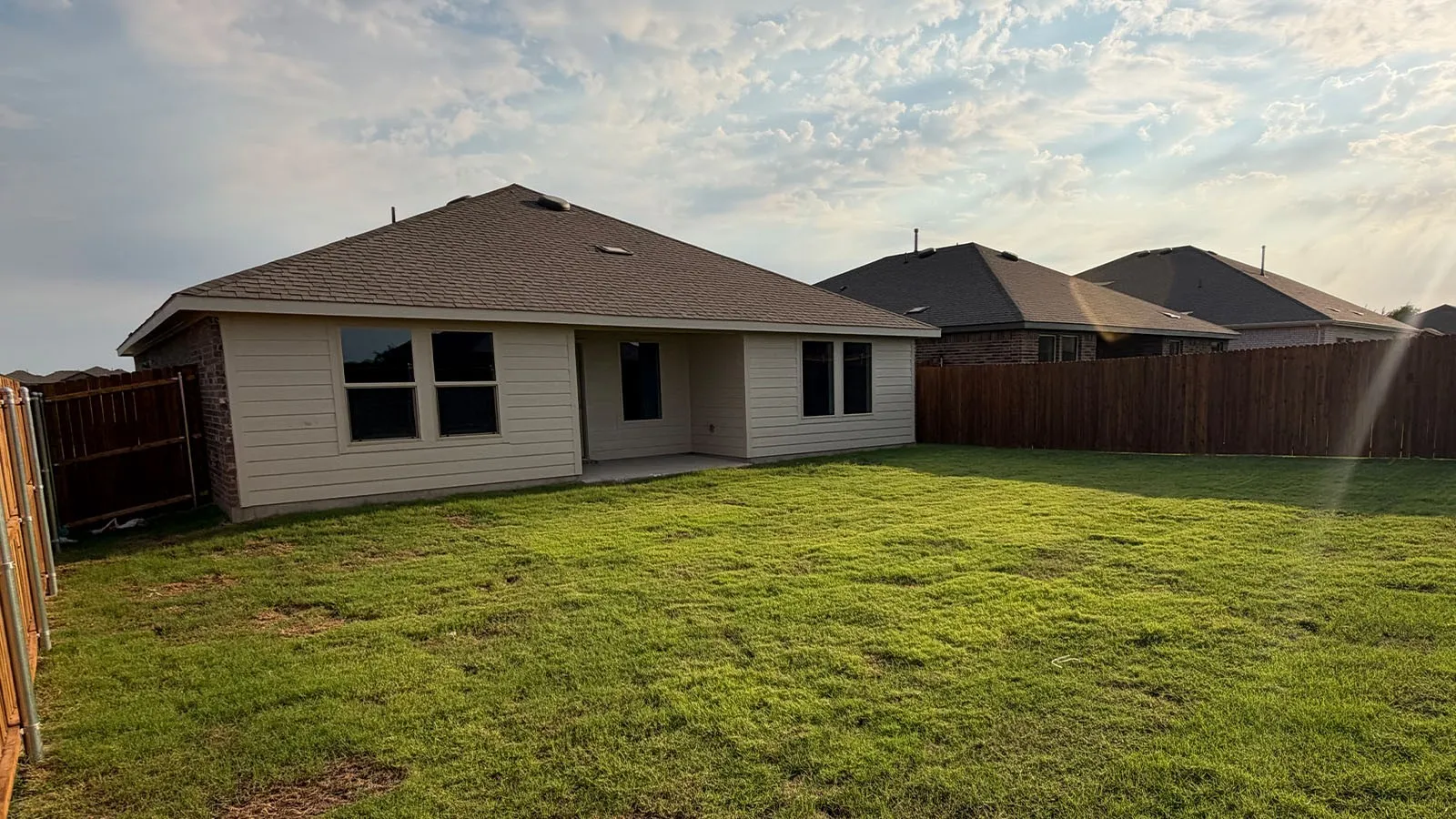 Expansive rear yard with a manicured lawn, complete with a privacy fence