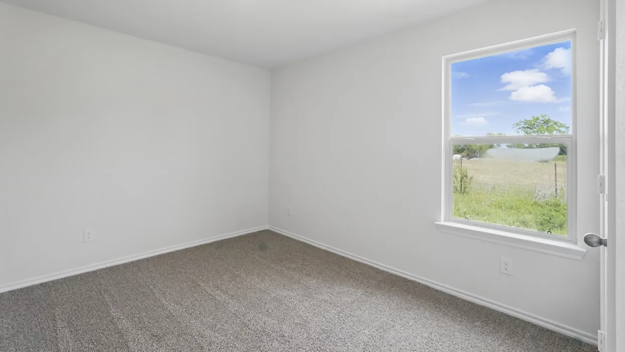 White painted walls with gray carpet flooring and a single-pane window