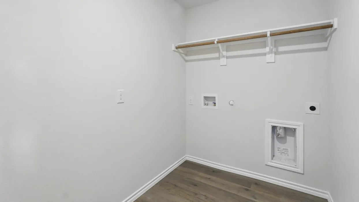 Wood-finish flooring, white baseboards, and a built-in hanging rod