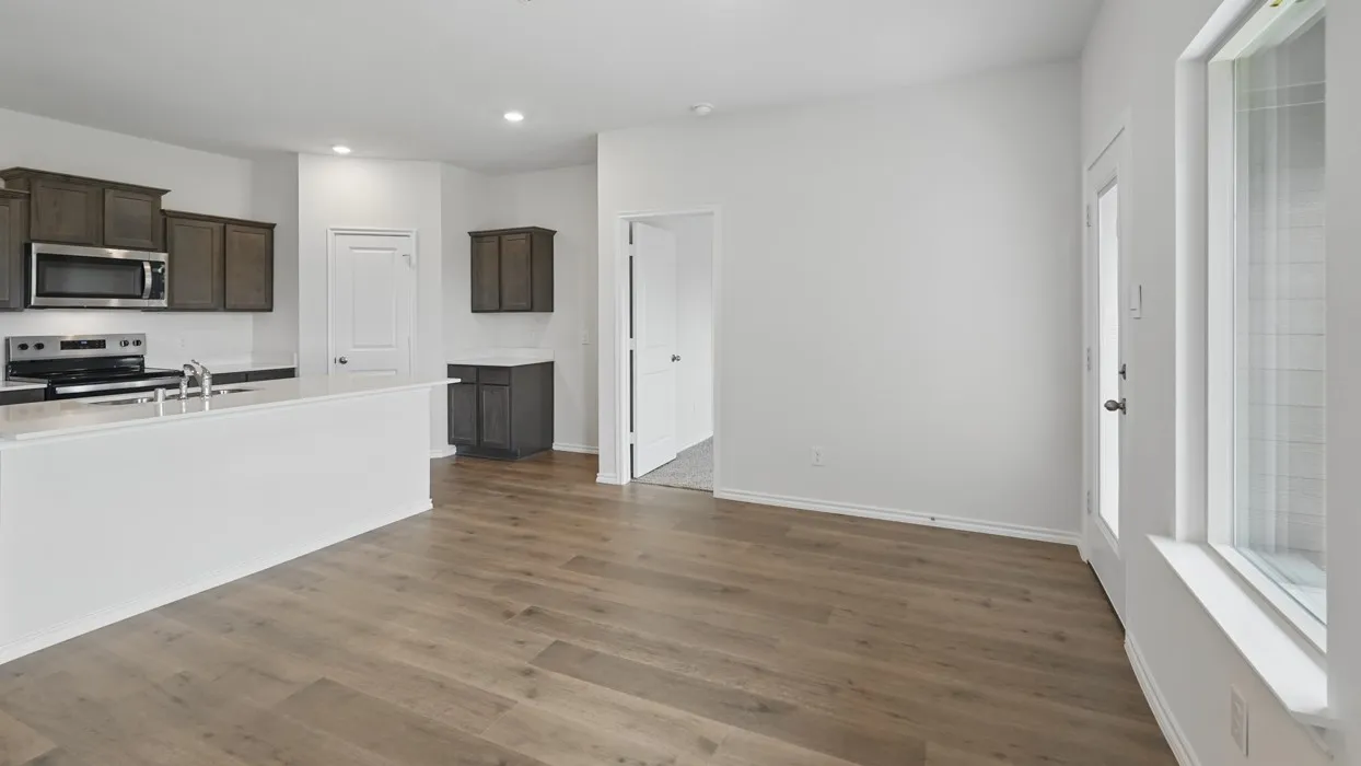 Open-concept living space with wood-finish flooring, white walls, and recessed lighting