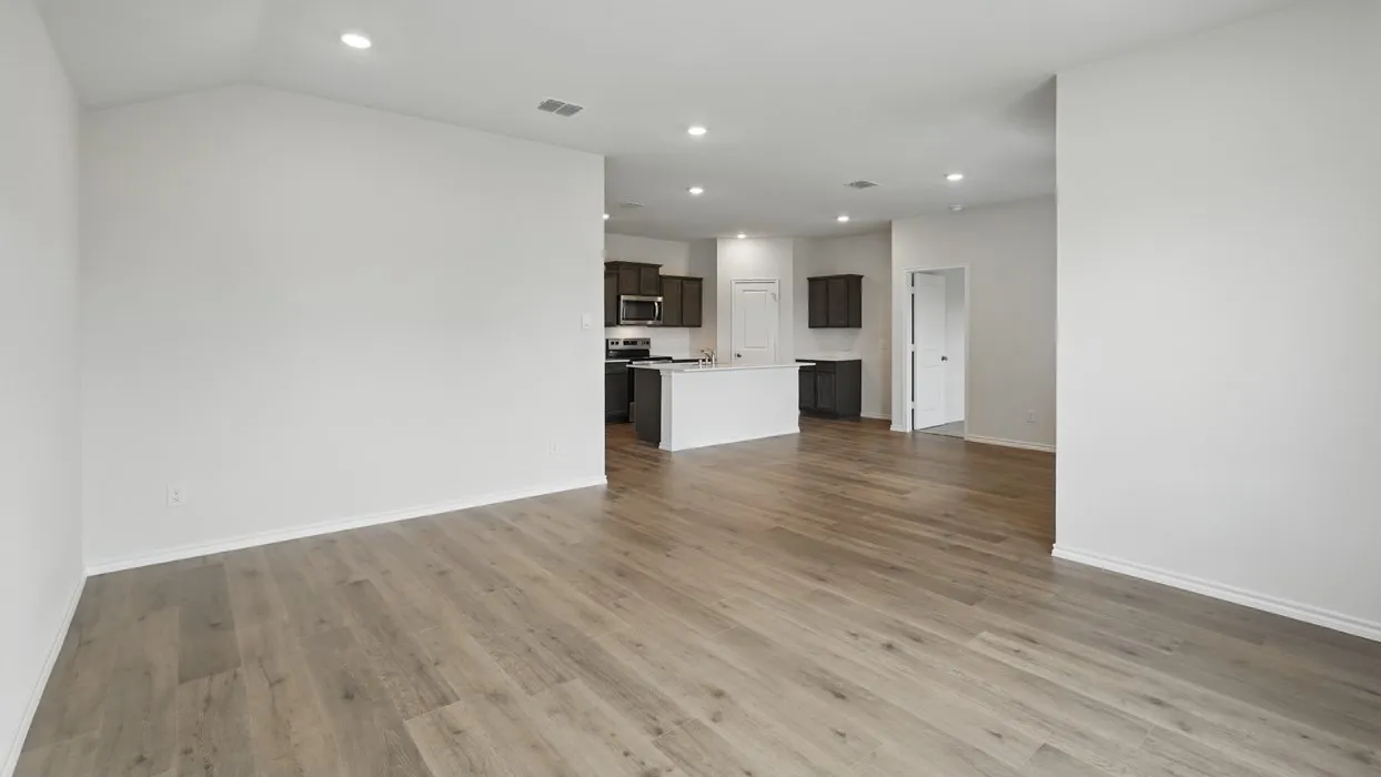 Wood-finish flooring throughout, recessed lighting, and a kitchen island with dark cabinetry