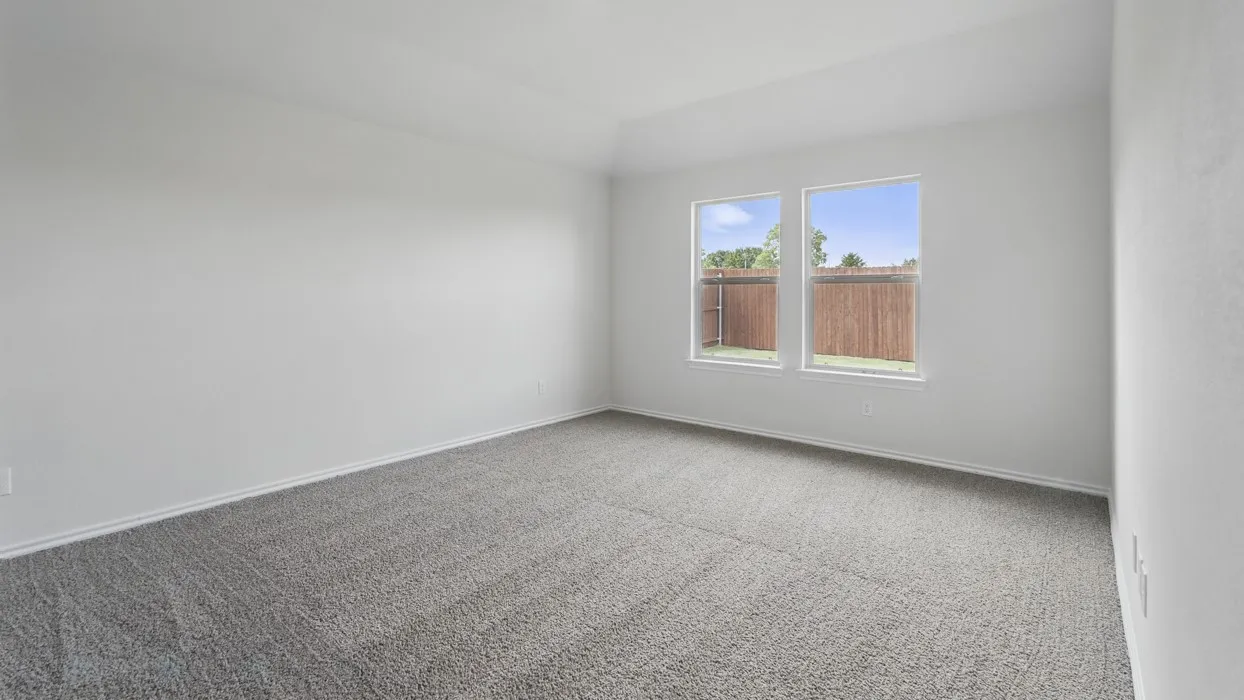 Spacious room featuring neutral carpeting, two windows, and light-colored walls