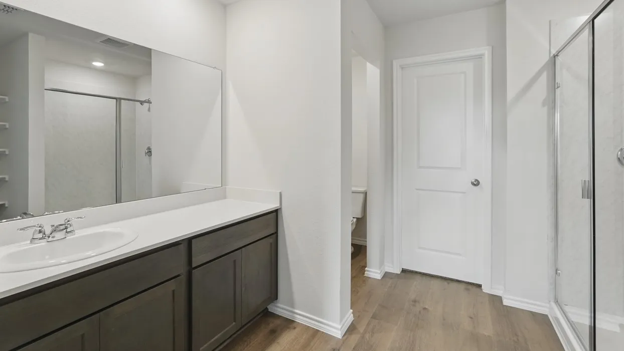 Vanity with an integrated sink, polished chrome faucet, and quartz countertop