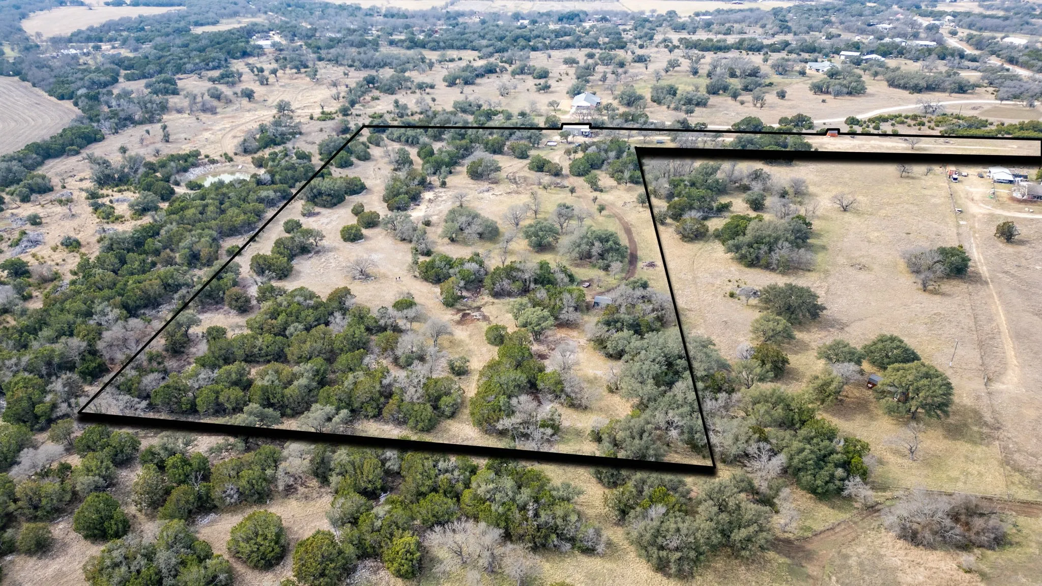 Expansive undeveloped land featuring mature trees and a natural pond