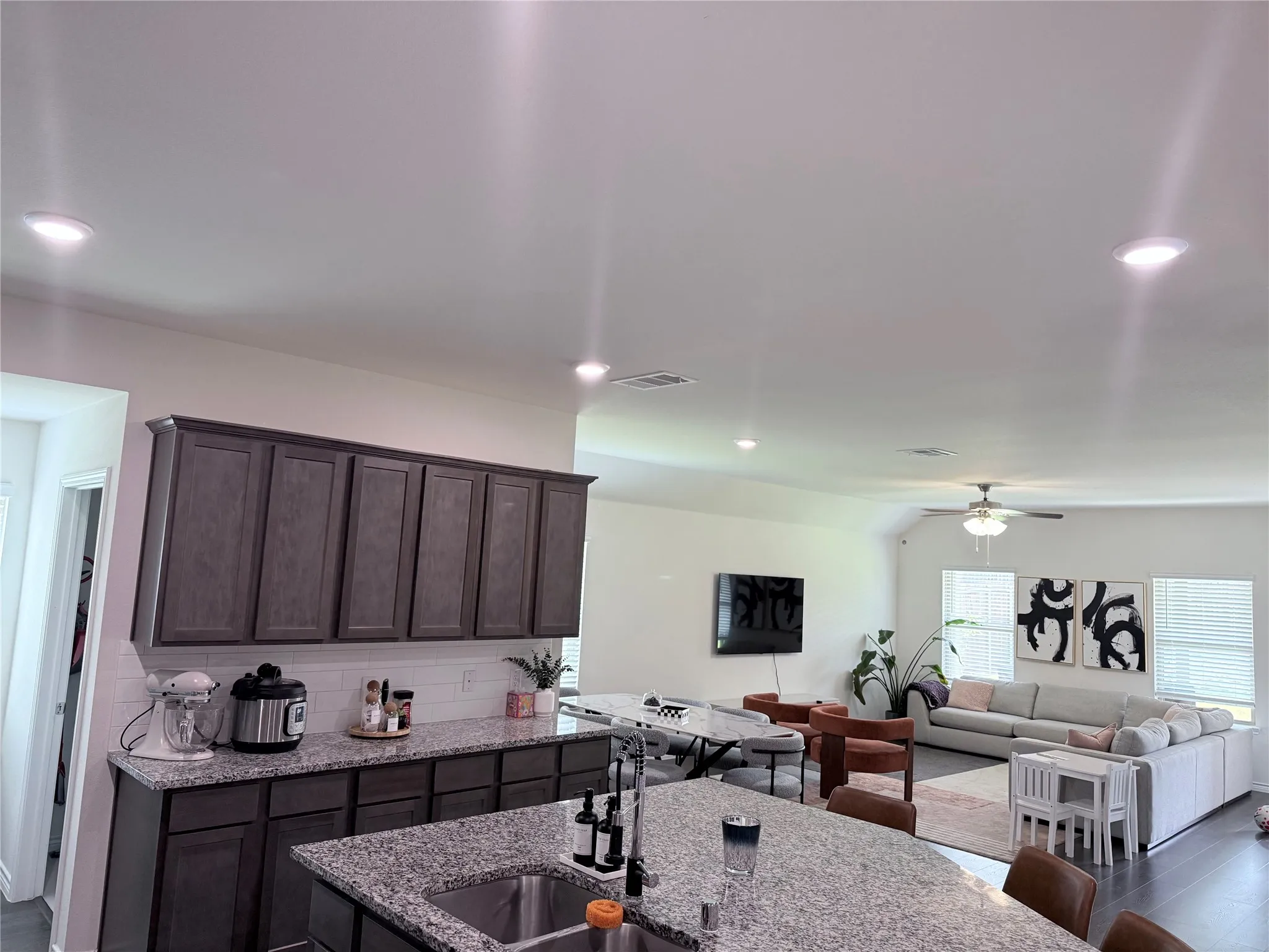 Kitchen featuring wood-finish cabinetry, granite countertops, and a tile backsplash
