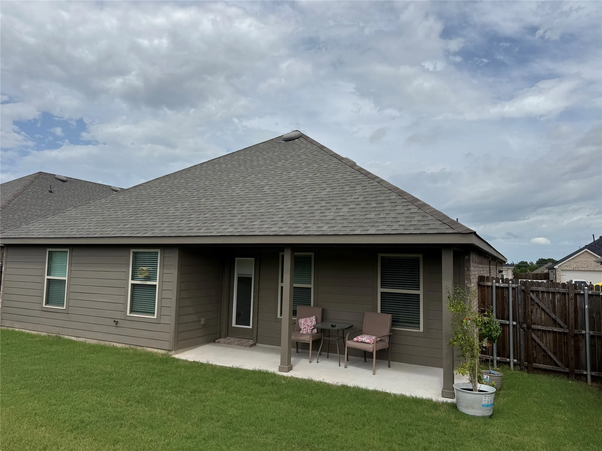 Covered patio with concrete flooring, shingle roof, and durable siding