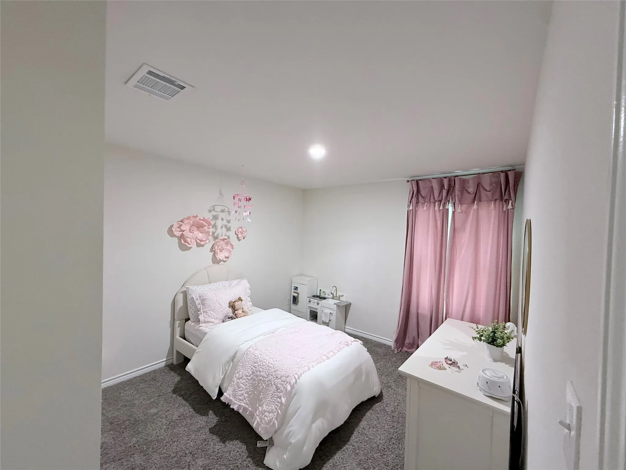 Recessed lighting, light gray wall paint, gray carpet flooring, and window treatments