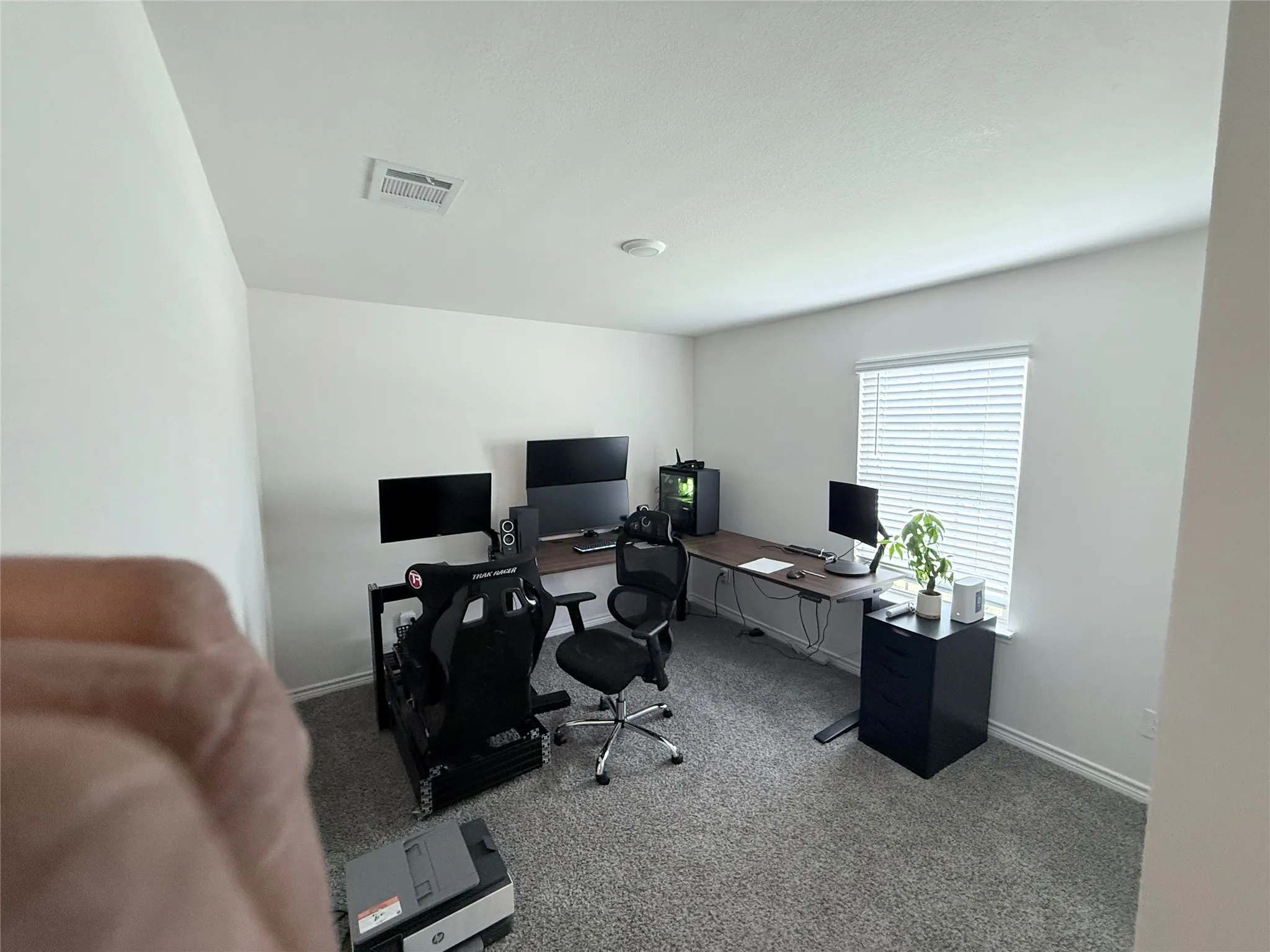 Carpeted flooring, white painted walls, and a window with blinds