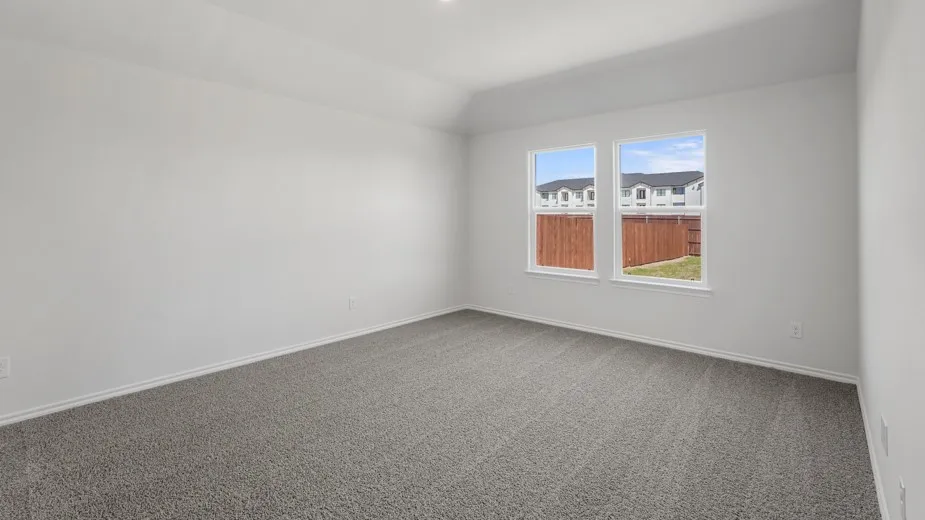 Recessed ceiling light, vaulted ceiling, two windows, gray carpet flooring, white walls