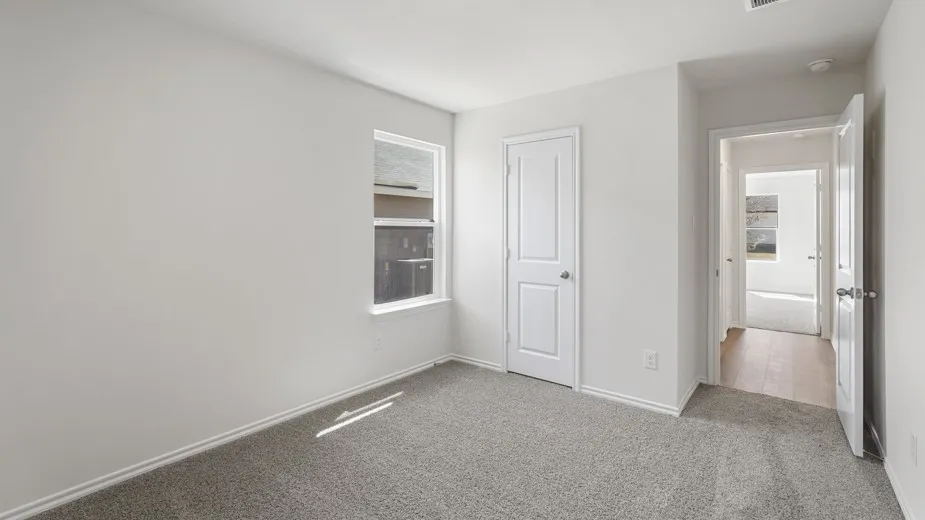 Neutral wall color, carpeted flooring, white trim, and a single window
