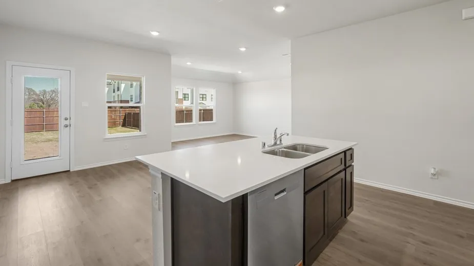 Kitchen island with white countertop, integrated double-basin sink, and dishwasher