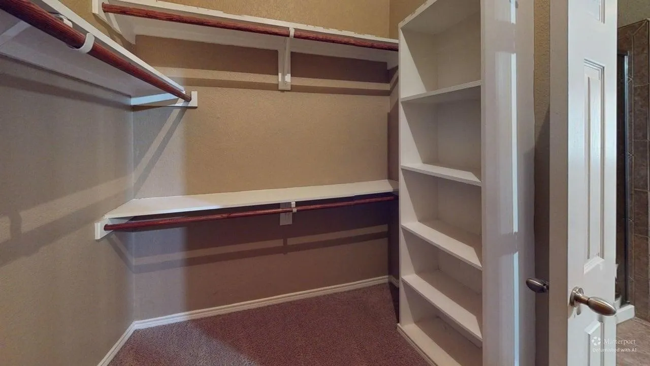 Built-in shelving, wood-finish hanging rods, and carpeted flooring
