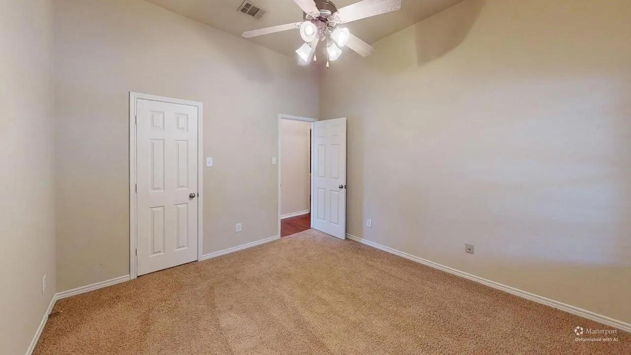 Vaulted ceiling, ceiling fan with integrated lighting, neutral wall tones, carpet flooring, white trim