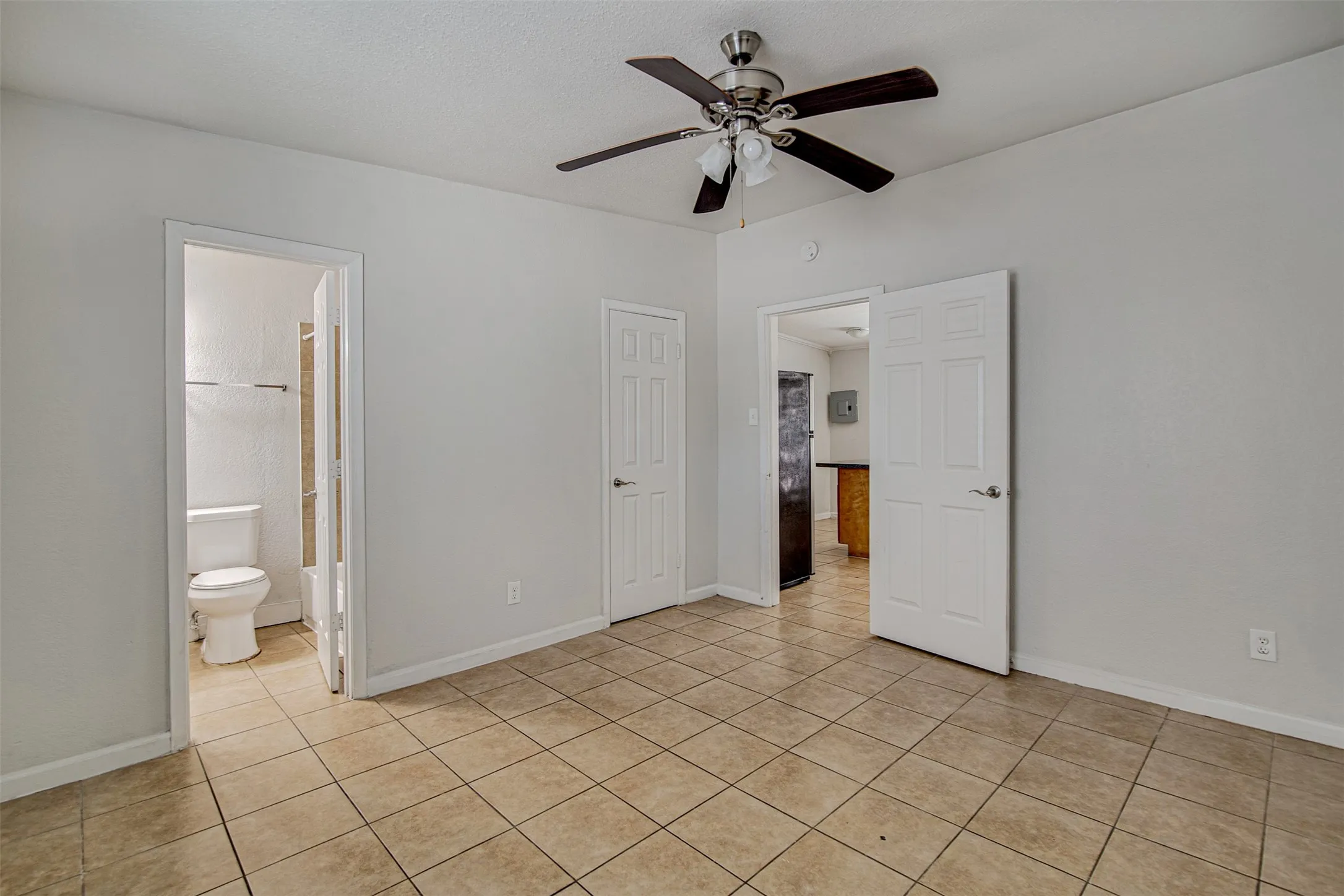 Recessed ceiling fan with integrated lighting, tiled flooring, and neutral wall paint