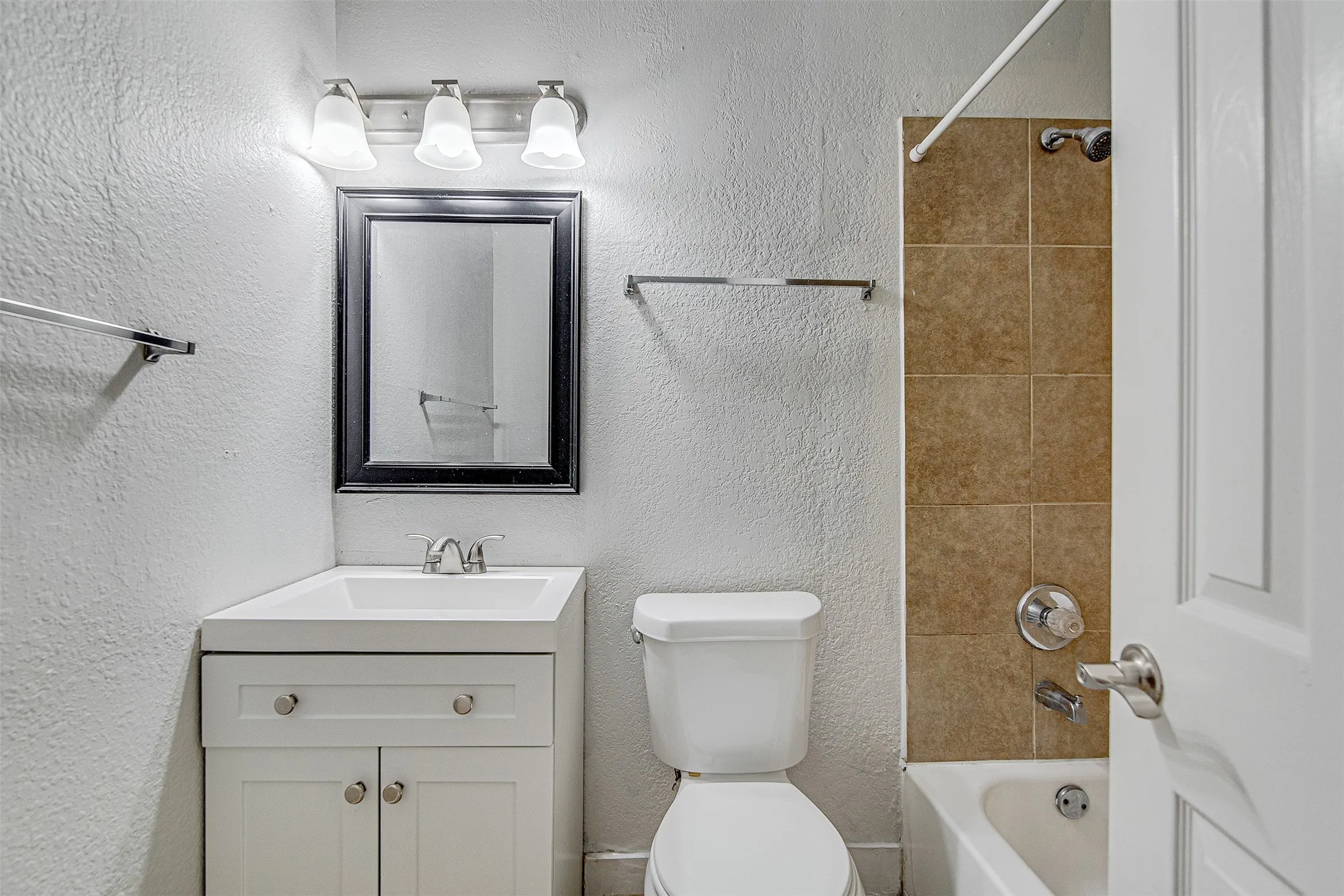 White vanity with dual cabinet doors, chrome hardware, and an integrated sink
