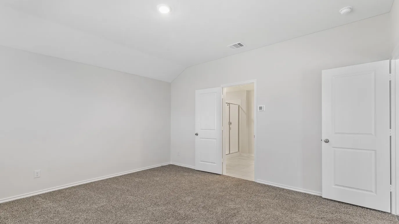 Vaulted ceiling with recessed lighting, light gray carpet flooring, and white interior doors