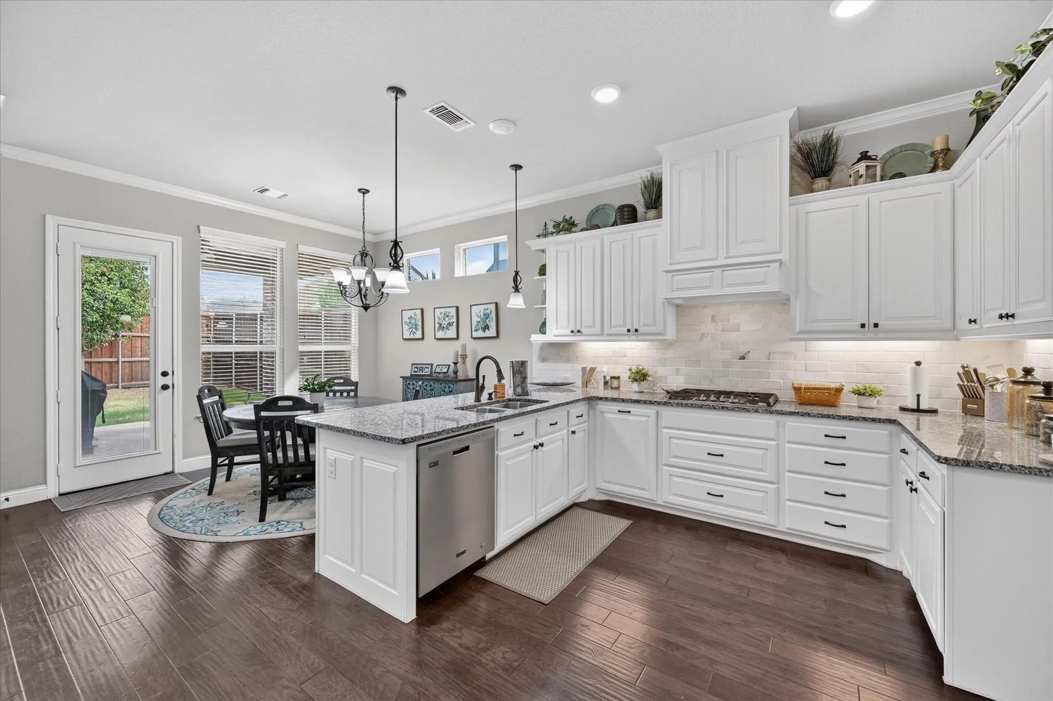 Kitchen featuring wood-finish flooring, white cabinetry, granite countertops, and a tile backsplash