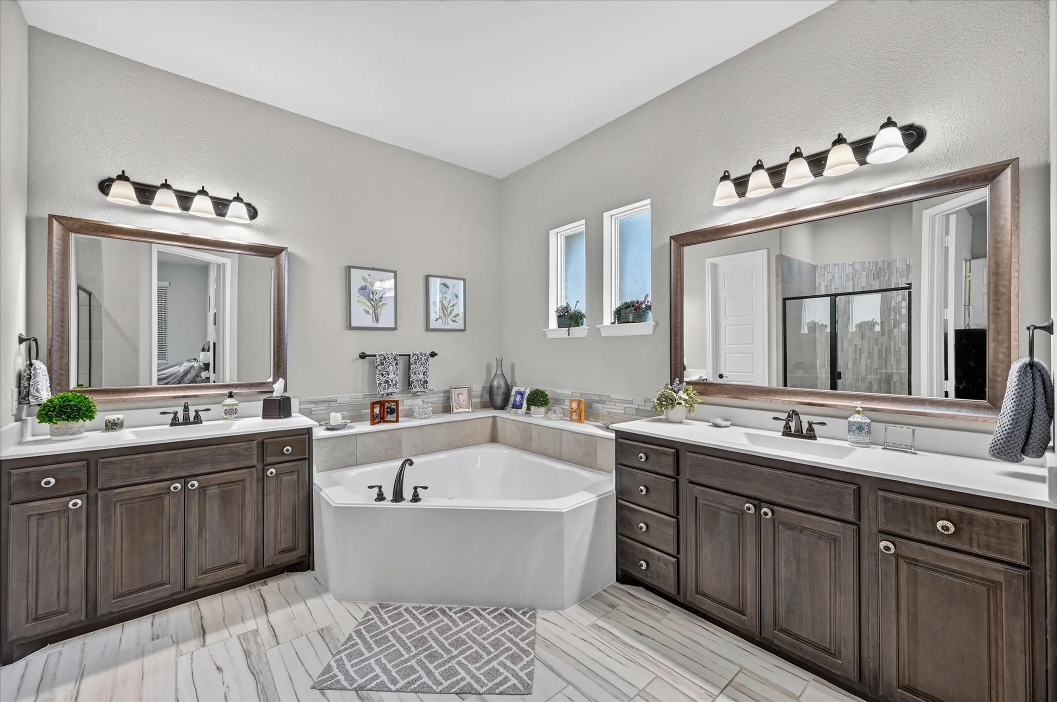 Dual vanities with white countertops and dark wood-finish cabinetry