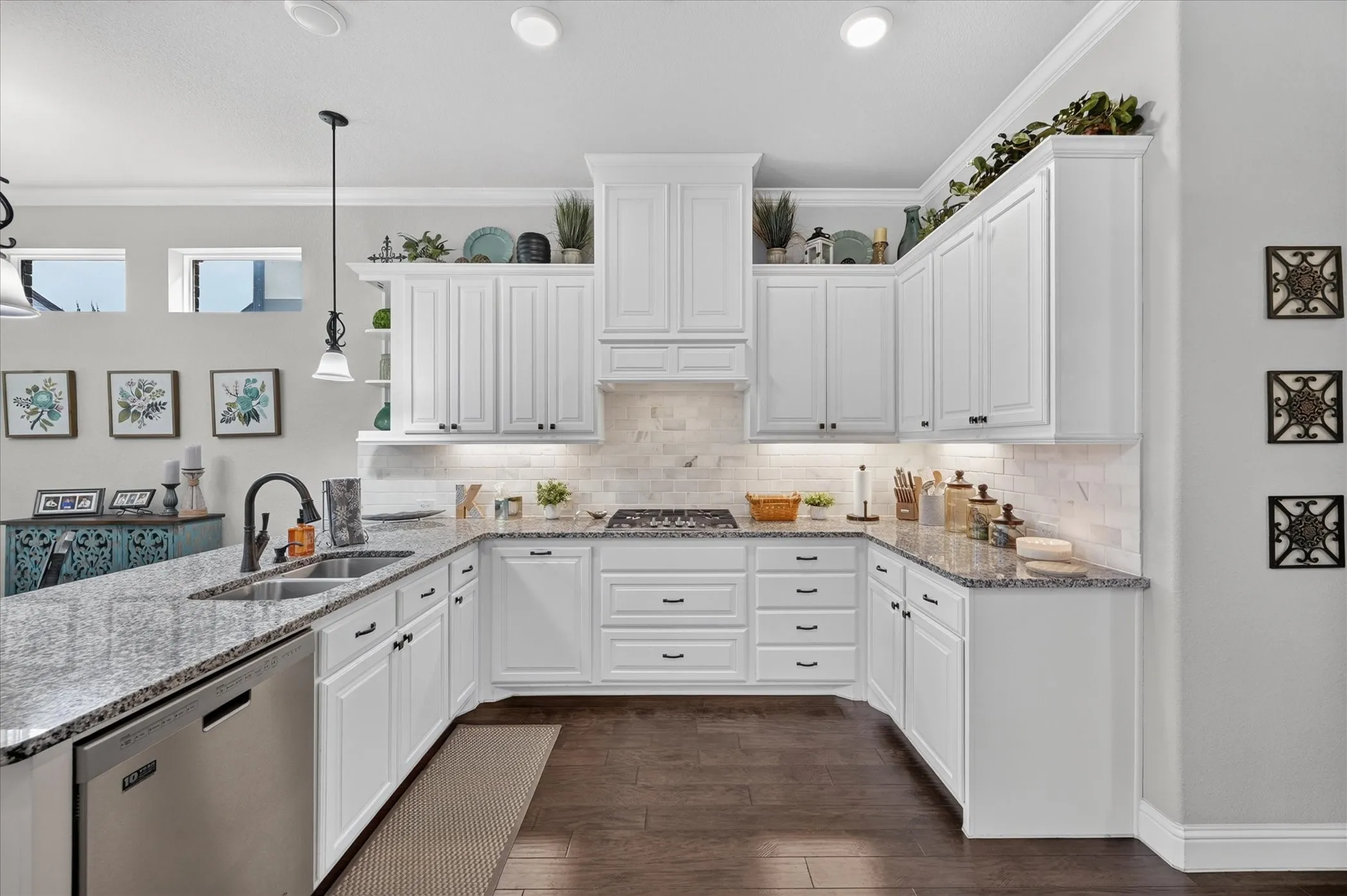 U-shaped kitchen featuring white cabinetry, granite countertops, stainless steel appliances, a tile backsplash, and dark wood-finish flooring