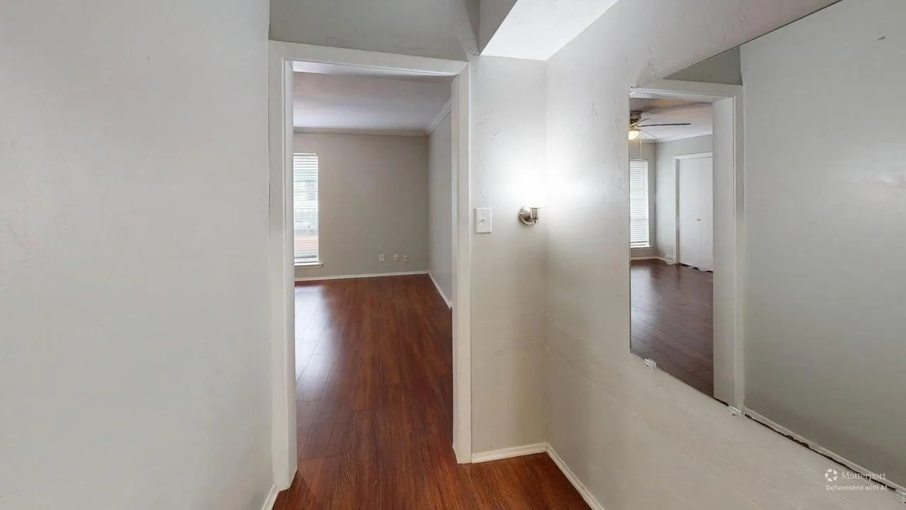Wood-finish flooring throughout, light gray wall paint, and a semi-flush mount light fixture