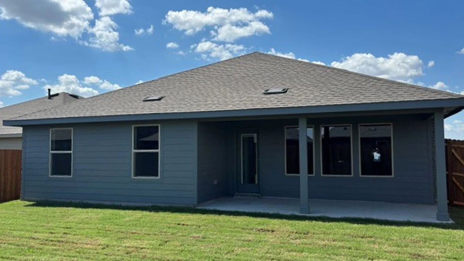 Expansive rear exterior featuring a covered patio, multiple windows, and a glass-paneled door
