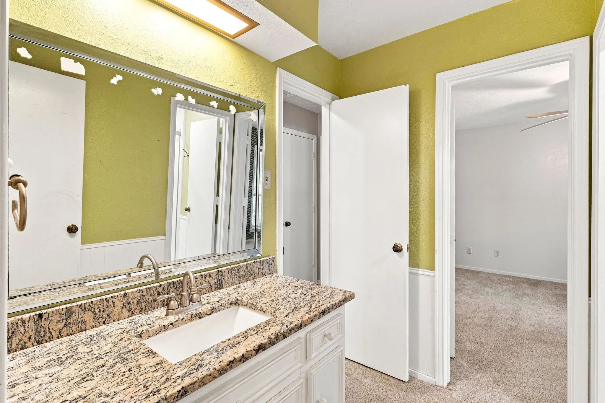 Vanity with a rectangular undermount sink, granite countertop, and brushed nickel faucet