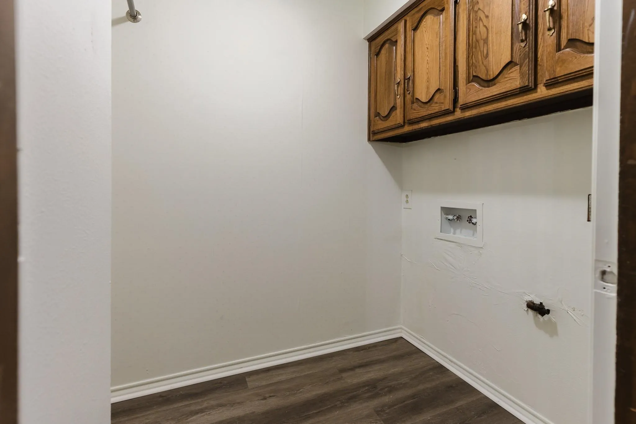 Wood-finish flooring, white walls, and built-in wood-finish cabinetry