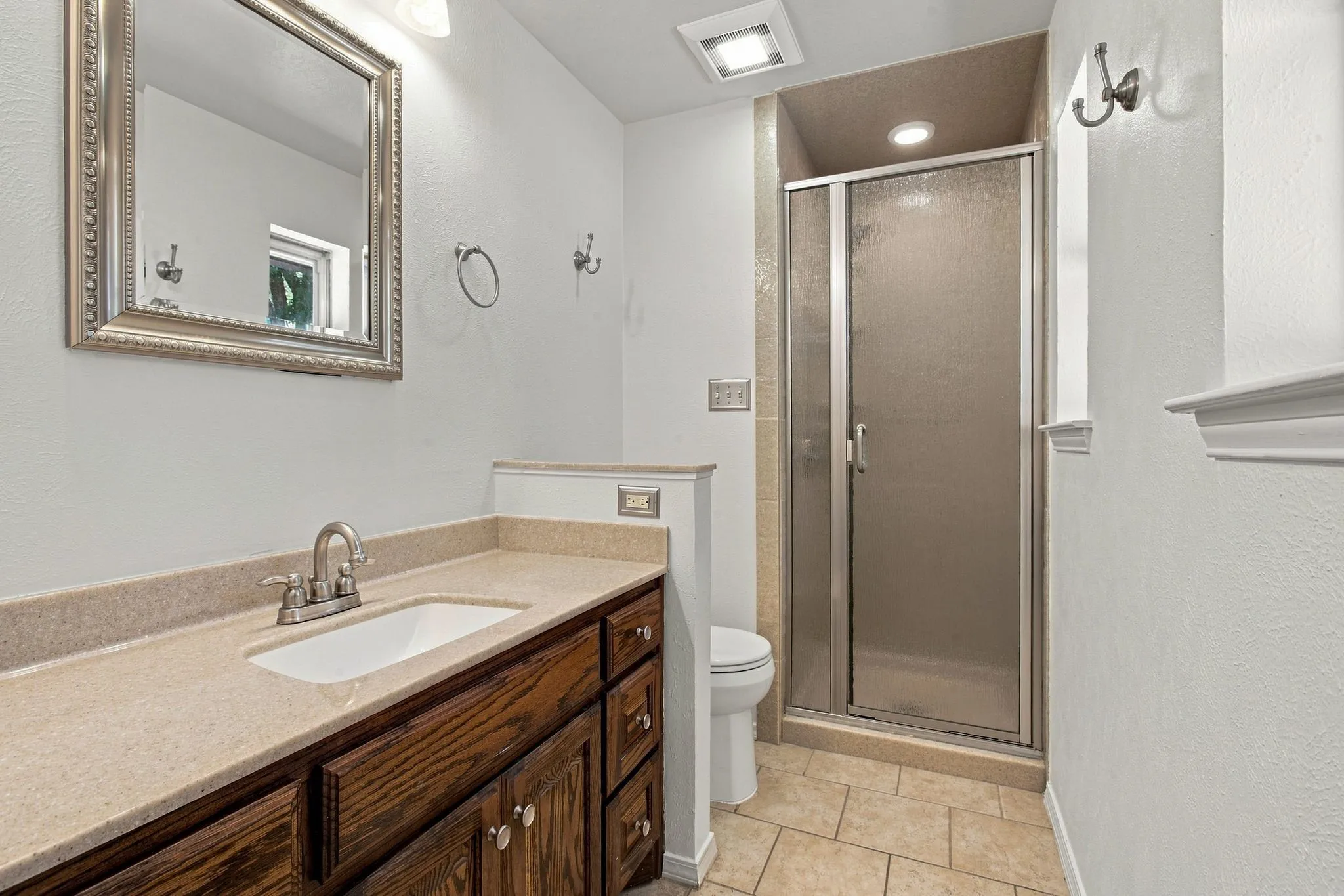 Wood-finish vanity and a stand up shower