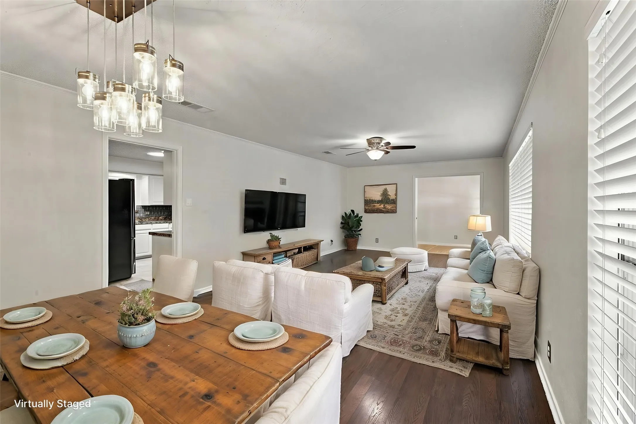 Open concept living space featuring dark wood-finish flooring, and a multi-light chandelier